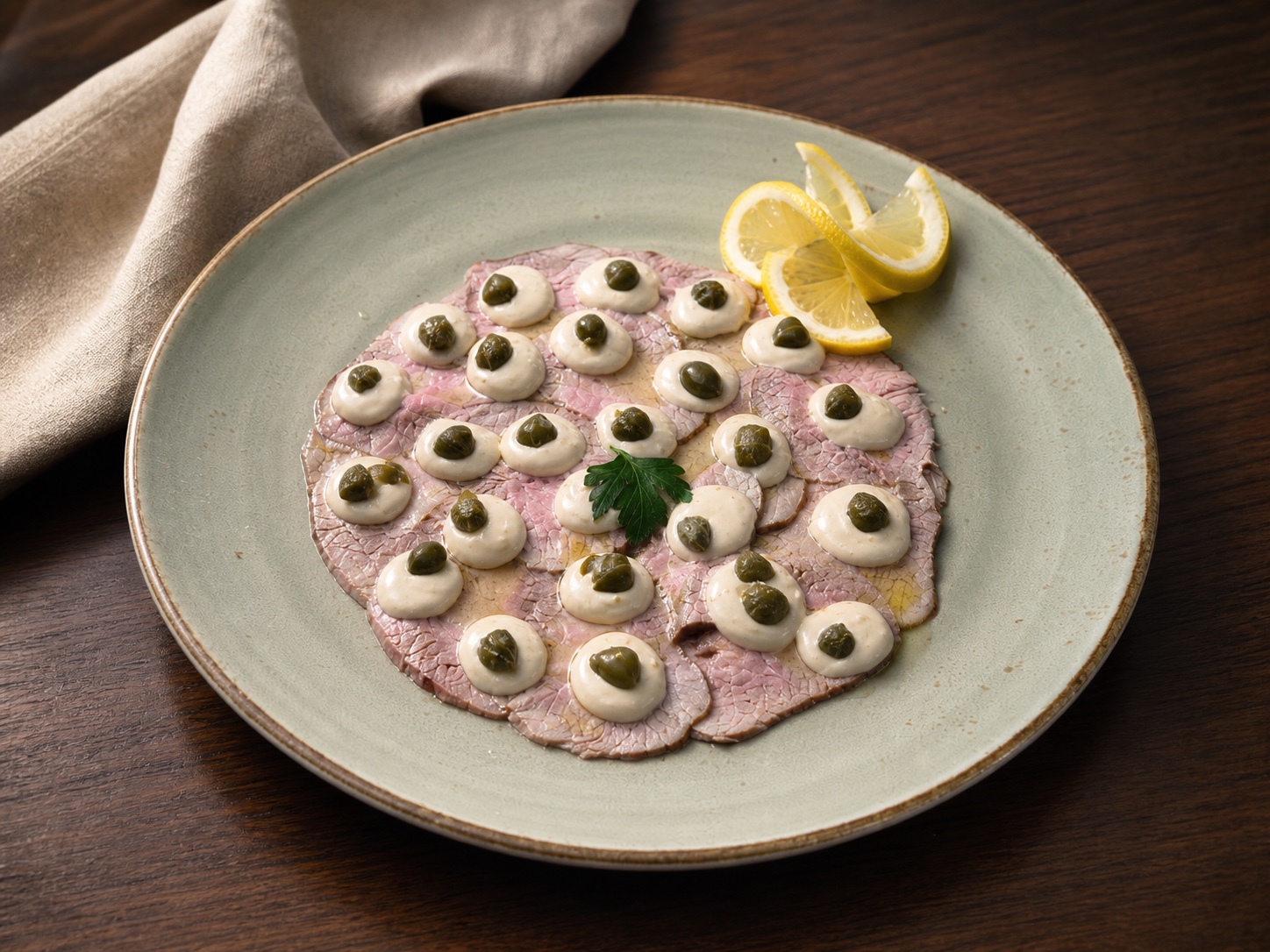 Fein angerichtetes Vitello tonnato mit Kapern und Zitrone